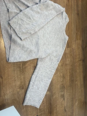 Ljusgrå stickad tröja XS - Mysig ljusgrå stickad tröja i enkel design. Tröjan har rund halsringning, långa ärmar och ribbade muddar vid ärmslut och nederkant. Perfekt för lager på lager och passar till det mesta i garderoben. Origami priset är 150kr tror jag är inte säker på modellen men den är jätte snygg på kan skicka fler bilder den är mer beige i verkligenheten andvänd  1 gång 