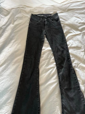 Svarta low flare jeans med utsvängda ben - Snygga svarta jeans med låg midja och utsvängda ben. Klassisk femficksmodell och smal passform upptill som går ut i en flare nertill. Pris kan diskuteras!
