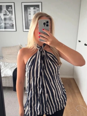 Randig halterneck topp - Säljer en söt halternecktop från Zara i storlek XS. Dock lite konstig att sätta på men det går! Köpt från Vinted men den har inte kommit till användning. Lånade bilder. Skriv för frågor!☺️