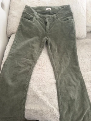 Gröna  bootcut jeans (Ordinarie pris: 699kr) - Snygga gröna  bootcut jeans, passform och klassiska fickor både fram och bak. Byxorna har en mjuk känsla och cool retrovibe, perfekta för dig som vill sticka ut lite extra. Stängs med knapp och dragkedja framtill.