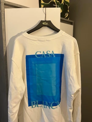 Aldrig använd Vit sweatshirt från Casablanca - Vit sweatshirt från Casablanca med blått grafiskt tryck på ryggen och mindre tryck på bröstet. med rund halsringning och ribbade muddar. Perfekt för en clean och modern look