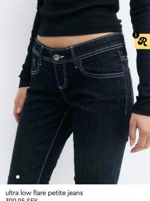 Mörkblå ultra low flare jeans - Snygga mörkblå jeans med ultra låg midja och utsvängda ben. Tydliga vita kontrastsömmar och klassisk femficksmodell. Perfekta för dig som gillar en trendig och retro vibe. Materialet är denim med stretch för extra komfort. Säljer då de inte kommer till användning💗