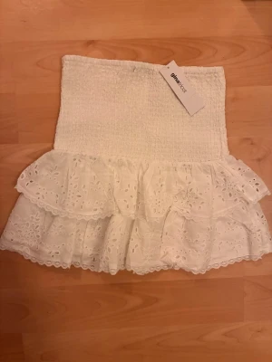 Vit broderad volangkjol Gina Tricot - Supersöt vit kortkjol från Gina Tricot med broderie anglaise och dubbla volanger. Kjolen har smock i midjan för skön passform och är perfekt till sommaren. Materialet är bomull och kjolen har fina spetsdetaljer och är i storlek S. Buda gärna! 🩷Helt oanvänd med prislapp.