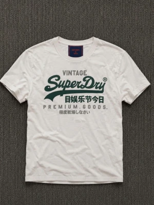 Vit Superdry t-shirt med tryck - Vit t-shirt från Superdry med grönt och grått tryck framtill. Klassisk rund halsringning och korta ärmar. Tillverkad i mjuk bomull för en bekväm känsla. Perfekt för dig som gillar streetwear och tydliga loggor.