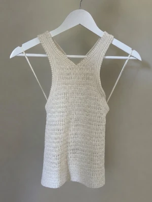 Stickad halternecktopp - Säljer en superfin stickad topp från Mango i ljus beige/offwhite ton ✨ Modellen har halterneck och öppen rygg, vilket gör den perfekt till sommaren, semester eller festligare tillfällen.