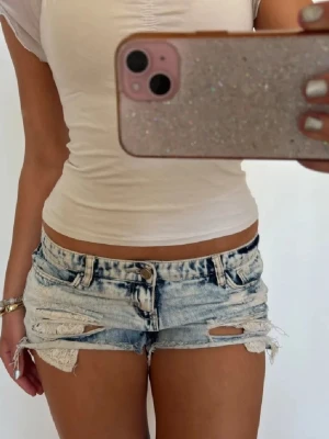 Lågmidjade blå shorts med spets - Såå fina ljusblå lågmidjade vintage jeansshorts med spets! midjemått rakt över: 36. Jag är 168 och det är mina bilder, köp via köp nu direkt eller Swish, kvar tills markerad som såld 💖 