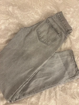 Grå straight jeans - Gina Tricot - Snygga grå jeans från Gina Tricot med rak passform och låg/medelhög midja. Säljer då dom inte passar längre. Jeansen är i storlek 32 och passade perfekt i längden på mig som var cirka 166 när jag köpte dom. Inga större defekter eller täcken på användning förutom det som syns i sista bilden🤍