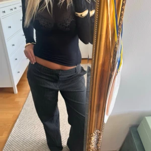 Randiga kostymbyxor i svart - Säljer ett par svarta randiga kostymbyxor. Byxorna har en rak passform och låg midja. Gammal kollektion från Gina tricot. Är 176 och bär vanligtvis storlek 38.