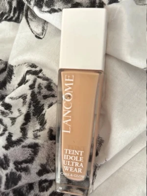 Lancôme Teint Idole Ultra Wear 115C - Foundation från Lancôme i nyansen 115C, Teint Idole Ultra Wear Care & Glow. Kommer i en stilren glasflaska med vit kork och rymmer 30 ml. Ger naturlig lyster, har SPF 25 och passar dig som vill ha en glowig finish.Mer än halva kvar inne.