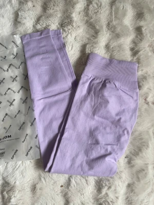 Dfyne lila NYA - Supersnygga ljuslila seamless leggings från Dyfine med hög midja och scrunch-detalj bak. Stretchigt material som sitter skönt och formar sig efter kroppen. Perfekta för dig som vill ha både stil och komfort i träningsgarderoben.