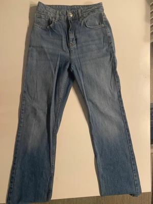 Ljusblå jeans  - Säljer ett par ljusblå jeans. Klassisk femficksmodell med bälteshällor. Materialet är denim i bomull.