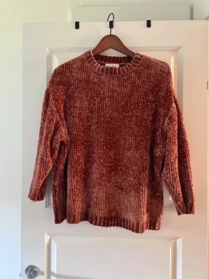 Rostfärgad chenilletröja från Wera - Mysig rostfärgad stickad tröja från Wera i mjuk chenille. Tröjan har rund halsringning, långa ärmar och ribbstickade muddar. Perfekt för dig som gillar en avslappnad och trendig look.
