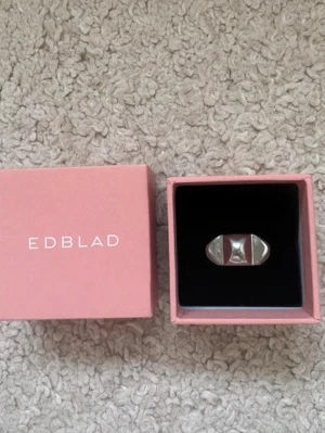 Silvrig ring från Edblad - Snygg och modern ring från Edblad i blankt silverfärgat metallmaterial. Ringen har en unik, geometrisk design med markerade kanter och levereras i original ask. Perfekt accessoar för att lyfta din stil.
