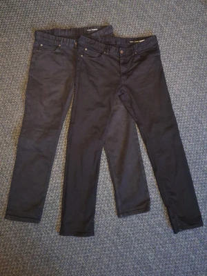 Jeans Dave slim fit W34 L30 Kappahl - Två par svarta jeans från Kappahl Dave slim fit. Ena paret är något ljusare i färgen från tvätt. 