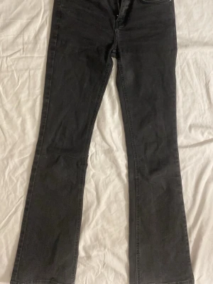 Svarta bootcut jeans - Svarta jeans med medel hög midja och är bootcut. märket Grunt men är köpta från kidsbrandstore. Jeansen har  resorb band i midjan så man kan ställa in så de passar. Dom har dock en liten skadda på en framsidan av benet nere vid foten som man kan se på sista bilden men kom privat om ni vill se mer bilder. Även färgen har blivit ljusare pgr tvättningar Det är därför jag säljer dom för lite billigare än vad dom egentligen gör. Det står inte vilken storlek men det är typ 164-170 (orginal pris 650kr)