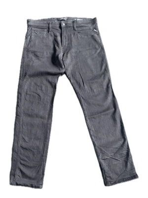 Svarta slim fit jeans från Replay  - Svarta jeans från Lee i slim fit-modell med klassisk femficksdesign och dragkedjegylf. Jeansen har raka ben och är tillverkade i ett stretchigt denimtyg för extra komfort. Perfekta för en stilren och avslappnad look.