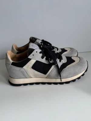 SWEYD - Grå & svarta sneakers - storlek 39 - Stilrena sneakers från kultförklarade sneakerstillverkaren SWEYD Footwear i storlek 39. Tidlös modell i grått och svart med ovandel i 100% äkta mocka / läder och textil. Skorna har svarta snören, vit logotyp på plösen och en stadig sula med grovt mönster. Perfekta för en trendig och avslappnad look, passar till allt. Nypris 2900:-. Mycket gott skick, som nya!