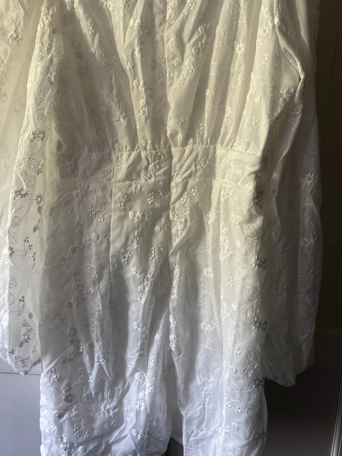 Vit broderad kortklänning med knappar och lång puffärm. Stl M - 3