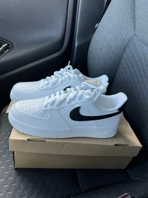 Nike Air Force 1 Vita Svarta Sneakers strl 42. - Helt nya & oanvända Nike Air Force 1 Vita Svarta Sneakers strl 42.  Skorna har inte blivit använda eller testade. Jag har lyckas slarvat bort original kartong. Därav pris. Pris kan diskuteras!  Nypris 1400 kr hos Nike!