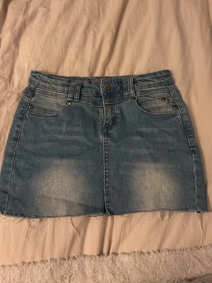 Blå jeanskjol med rå kant - Snygg blå jeanskjol, lite upsprättsd i mitten sömmen fram!