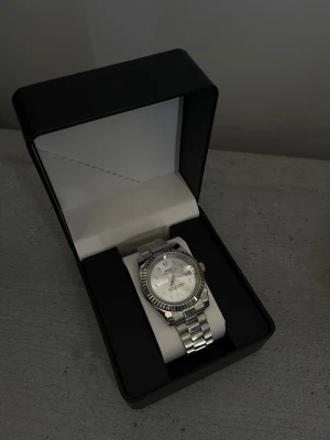 Seiko silverfärgad armbandsklocka - Stilren armbandsklocka från Seiko i silverfärgat rostfritt stål. Perfekt accessoar för dig som gillar en clean och elegant look.                                                     Specifikationer: Storlek: 39mm Urverk: NH35 (Automatiskt) Material: 904L Rostfritt Stål Glas: Sapphire Glas Tavla: Silver med arabiska siffror Bezel: Räfflad Armband: Presidential länk Krona: Screw Down Vattentålighet: 30  