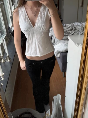 Vit omlott linnetopp med v-ringning💖 - Säljer en söt vit omlott linnetopp med djup v-ringning och ärmlös design. Toppen har en croppad passform och är perfekt för dig som gillar en enkel och stilren look. Materialet är lätt och luftigt, perfekt för varma dagar!!!