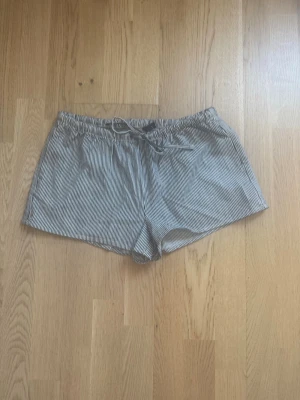 Lågmidjade randiga shorts med snörning - Säljer ett randiga shorts i lite tjockare material med låg midja och snörning. Shortsen är från H&M i storlek S och är oanvända med prislapp kvar.