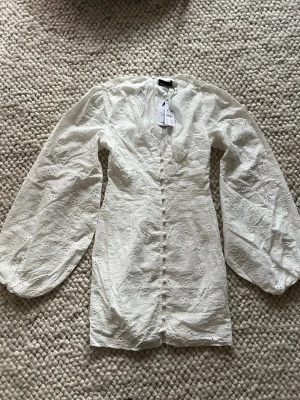 Vit kort klänning med puffärmar - Säljer en vit kort klänning från Gina tricot endast testad