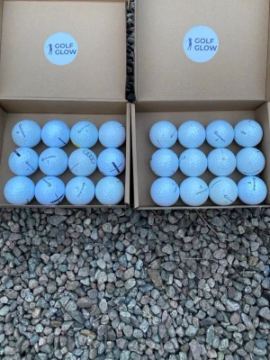 Taylormade mix 24-pack  - Två lådor med vita golfbollar från Golf Glow. Bollarna har klassisk rund form och är märkta med olika logotyper, bland annat TaylorMade och Audi. Perfekt för golfentusiasten som vill fylla på sitt förråd.