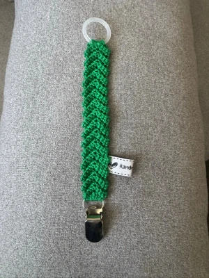 Virkad napphållare - Virkad, grön napphållare. Virkad av mig i 100% bomullsgarn med metallclip och silikonring.  Mönsterskapare: animo.design