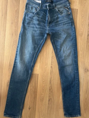 Blå Jeans Replay - Snygga blå jeans från Replay, modell MICKYM, med slim tapered fit. Säljer pga av att de är för små. Hör av dig vid frågor! 