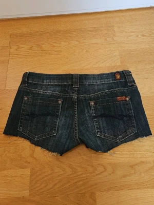 Mörkblå low waist jeansshorts från Seven7 - Snygga vintage mörkblå lågmidja jeansshorts från Seven7 med fin bakfick design. Shortsen har låg midja och är i nytt skick. Säljer på grund av att dem är för stora på mig! Pris kan diskuteras!🫶