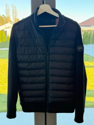 Canada goose cardigan Black label - Säljer denna otroligt snygga canada goose cardigan i färgen svart. Den har den klassiska och snygga black labeln. Den är självklarligen äkta och kvitto medföljs vid köp. Köpt på NK i Stockholm.