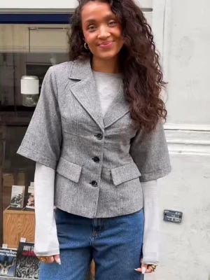 Grå kortärmad kavaj - Jättesnygg kort kappa/kavaj med svarta knappar och vida ärmar! Endast använd en gång. Nypris 1500kr☺️💗