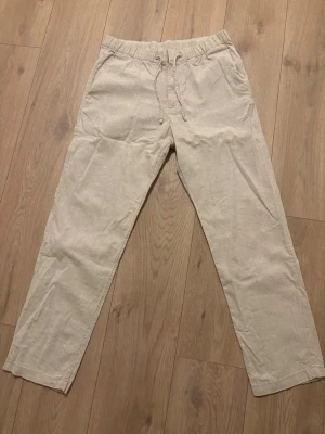 Beiga linnebyxor från H&M - Säljer ett par beiga linnebyxor från H&M med relaxed fit. Storlek s, andvända ca 2 ggr