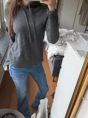 Stickad mörkgrå  hoodie med luva💓 - Mörkgrå hoodie med luva och dragsnören, tillverkad i mjukt stickat material. Tröjan har ribbade muddar vid ärmslut och nederkant, vilket ger en skön passform. Perfekt för dig som gillar en enkel och stilren look. Stickad och jätte skön, passar till allt 💓