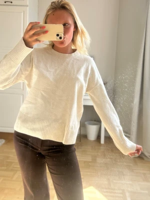 Vit stickad tröja med rund hals💖💖 - Säljer en enkel och stilren vit stickad tröja med rund hals och långa ärmar. Tröjan har ribbstickade muddar vid ärmslut och nederkant, vilket ger en snygg och avslappnad look. Perfekt att matcha med jeans eller mjukisbyxor.