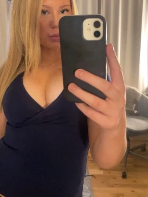 Mörkblå omlottopp från Nelly - Snygg mörkblå omlottopp från Vero Moda med v-ringad design och korta ärmar. Perfekt för dig som gillar en enkel men stilren look. Toppens material är mjuk bomull som känns skönt mot huden och passar bra till jeans eller kjol.