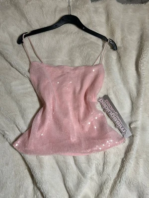 Rosa paljettopp från Missguided - Supersöt ljusrosa topp från Missguided med tunna axelband och glittriga paljetter över hela tyget. Toppen har en croppad passform och är perfekt för att sticka ut. Perfekt för sommar och utgång🌸🫶💕