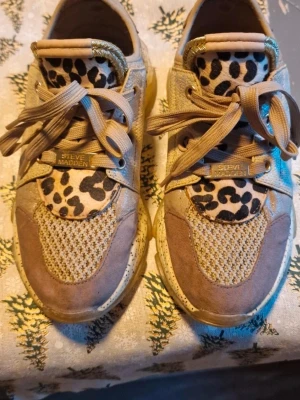 Beige leopardmönstrade sneakers Steve Madden - Säljer ett par beigeGuldiga  sneakers från Steve Madden med leopardmönstrade 