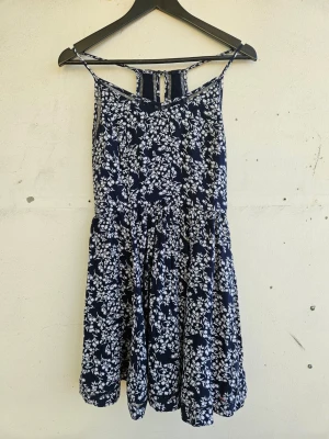Marinblå blommig sommarklänning - Söt marinblå klänning med vitt blommönster och tunna axelband från Superdry. Storlek XS.