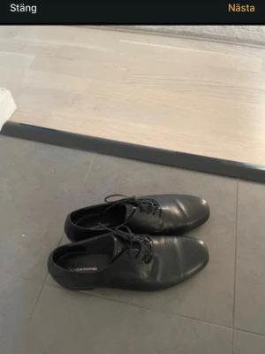 Svarta loafers från Vagabond som NY - Säljer ett par klassiska svarta loafers från Vagabond i slätt läder. Skorna har rundad tå, låg klack och snörning framtill för en stilren look. Perfekta för dig som gillar minimalistisk och tidlös design.