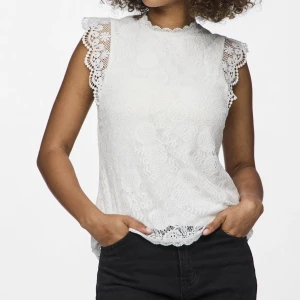 Vit spetsblus från Pieces  - Snygg vit blus i spets från Pieces med ärmlös design och fina spetsdetaljer vid axlarna. Perfekt för en elegant look. Knappt använd!! Skriv för egna bilder 💕