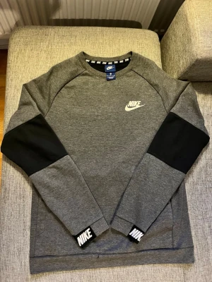 Grå Nike sweatshirt  - Snygg grå sweatshirt från Nike. Tillverkad i mjukt material, perfekt för en sportig och avslappnad stil.