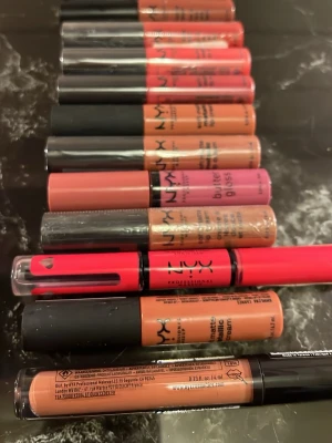 NYX läppglans och lip cream set - Säljer ett set med flera NYX läppglans och soft matte lip creams i olika färger som nude, rosa, röd och brun. Produkterna har klassisk tubform med svart lock och är perfekta för att skapa olika looks. Innehåller både butter gloss och soft matte metallic varianter.