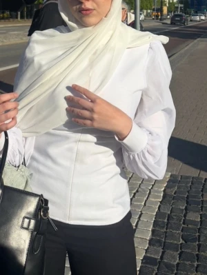 Vit figursydd blus med puffärm Karen millen - Stilren vit blus med figurnära passform och puffiga axlar. Blusen har långa ärmar och markerad midja som ger en snygg siluett. Tillverkad i ett slätt tyg som känns bekvämt och passar till många olika looks.