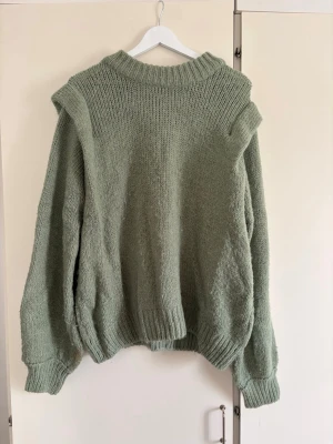 Grön stickad tröja från Gina Tricot - Mysig stickad tröja i ljusgrönt från Gina Tricot. Tröjan har en bred ribbad krage, långa ärmar och ribbade muddar vid ärmslut och nederkant. 