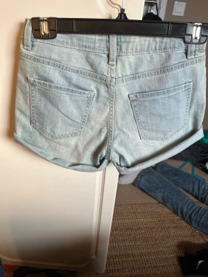 Ljusblå jeansshorts - Snygga ljusblå jeansshorts från Your Denim Your Rules med klassisk femficksdesign och bälteshällor. Shortsen har en avslappnad passform och är tillverkade i mjukt denimtyg. Perfekta för en chill och trendig sommarstil.