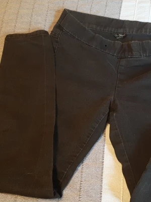Svarta skinny jeans från KappAhl - Svarta skinny jeans från KappAhl med klassisk femficksdesign och stretchigt material för en bekväm passform. Snyggt smala ben och normal midja, perfekta till en avslappnad stil. Längden mäts till cirka 100 cm. Jag tror storlek 42/44.