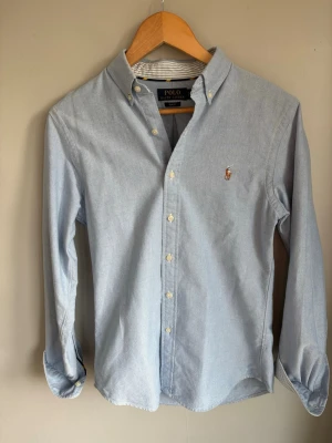 Ljusblå skjorta från Polo Ralph Lauren - Klassisk ljusblå skjorta från Polo Ralph Lauren med broderad logga på bröstet. Perfekt till våren nu och om du vill klä upp dig lite! Väldigt stilrent passar till allt. Skick: 10/10 Storlek: S                                                           Hör av er vid minsta fundering!                                              //Ville